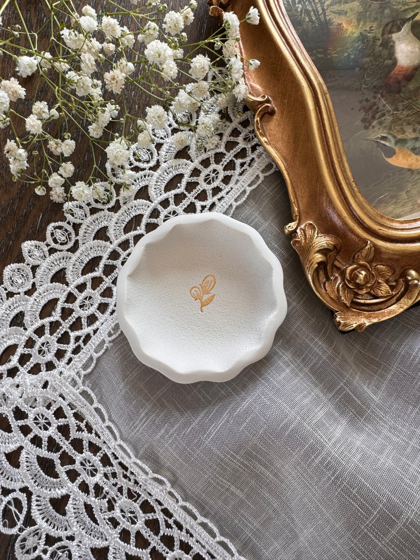 scalloped edge white clay ring dish with gold flower in center in flat lay photo, perfect for flat lay kit