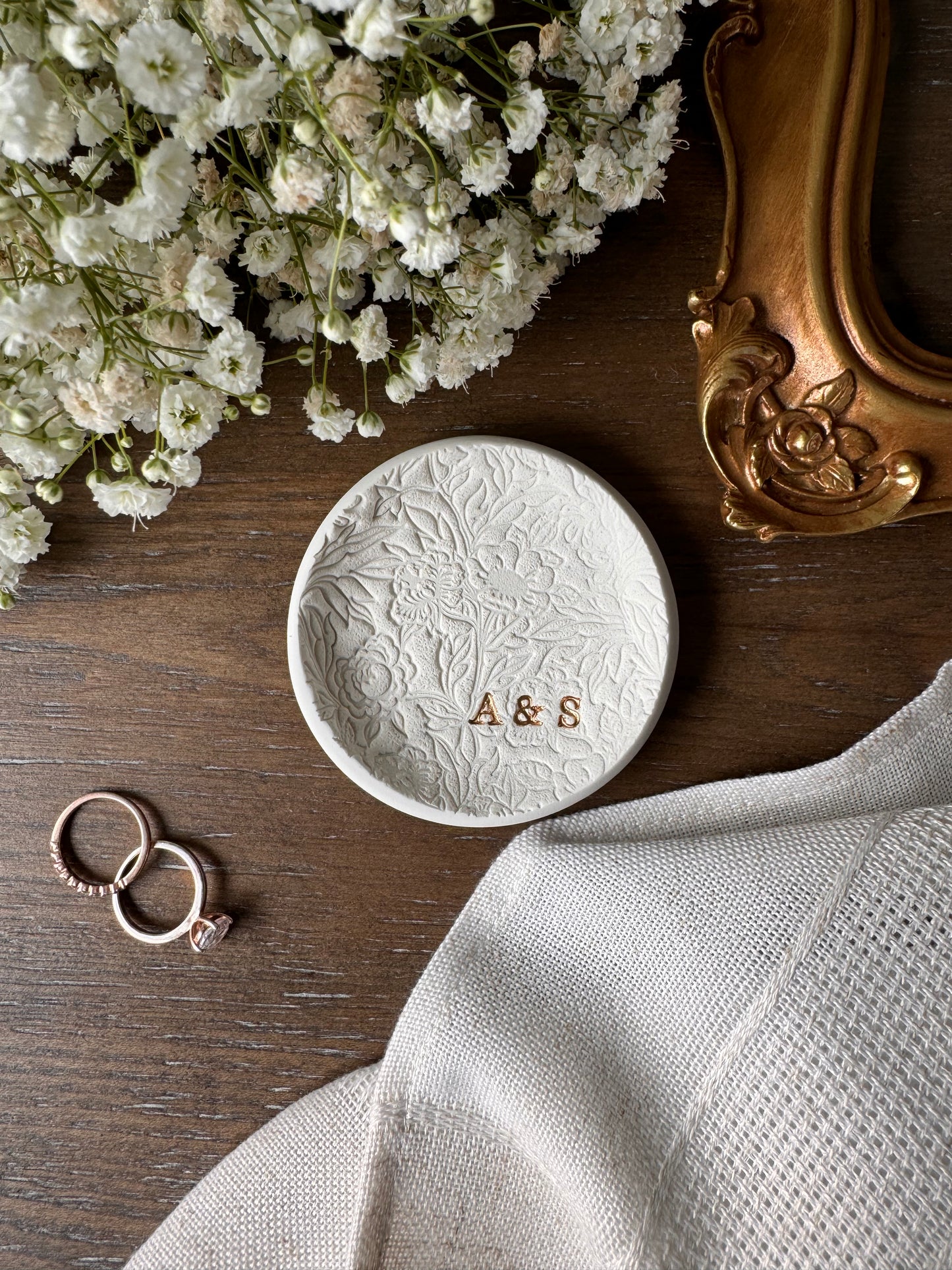 floral textured design ring dish made of white clay with initials in bottom right of dish in gold