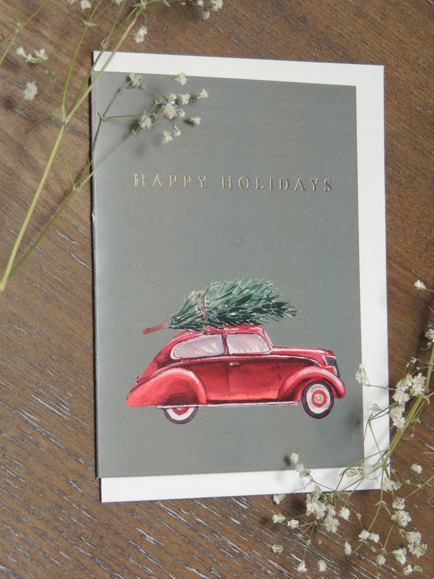 happy holidays card with vintage red car and Christmas tree on front