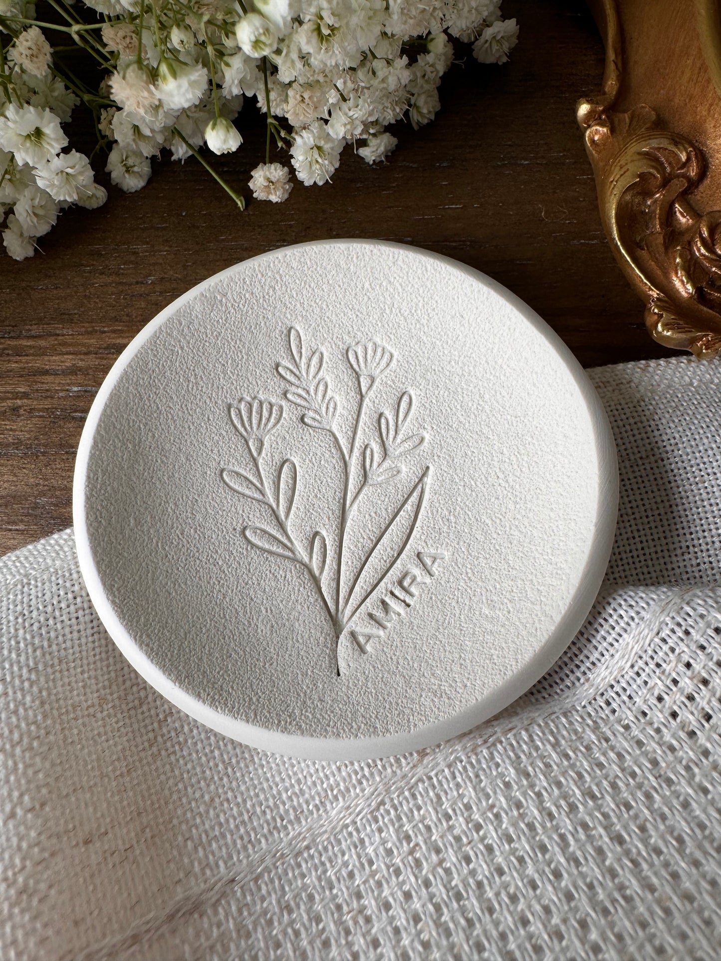 white ring dish with large flower design embossed and personalized name in center