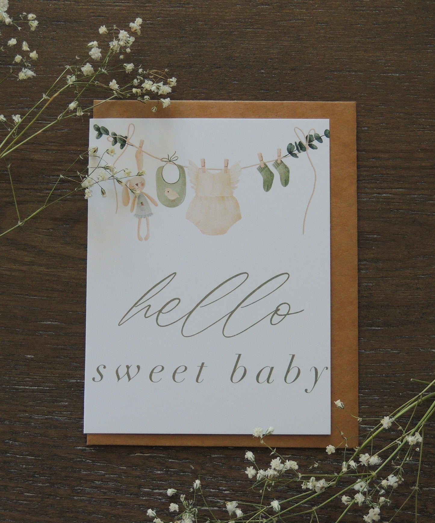 card with "hello sweet baby" card on the front and watercolor baby clothes