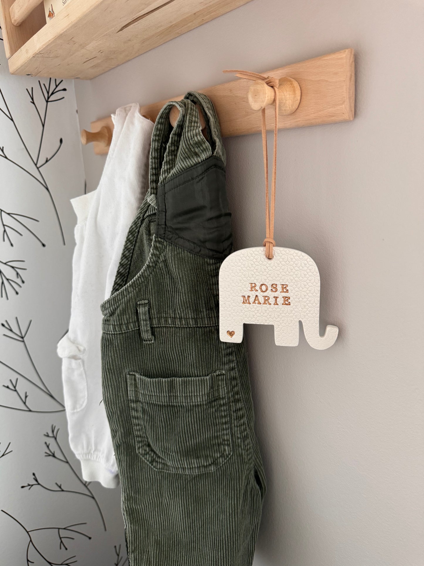 elephant shaped white clay ornament with personalized baby name in gold writing