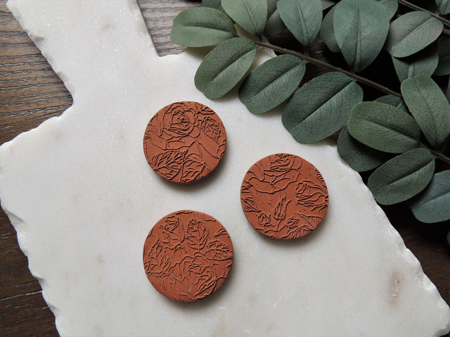 terracotta colored magnets with floral pattern