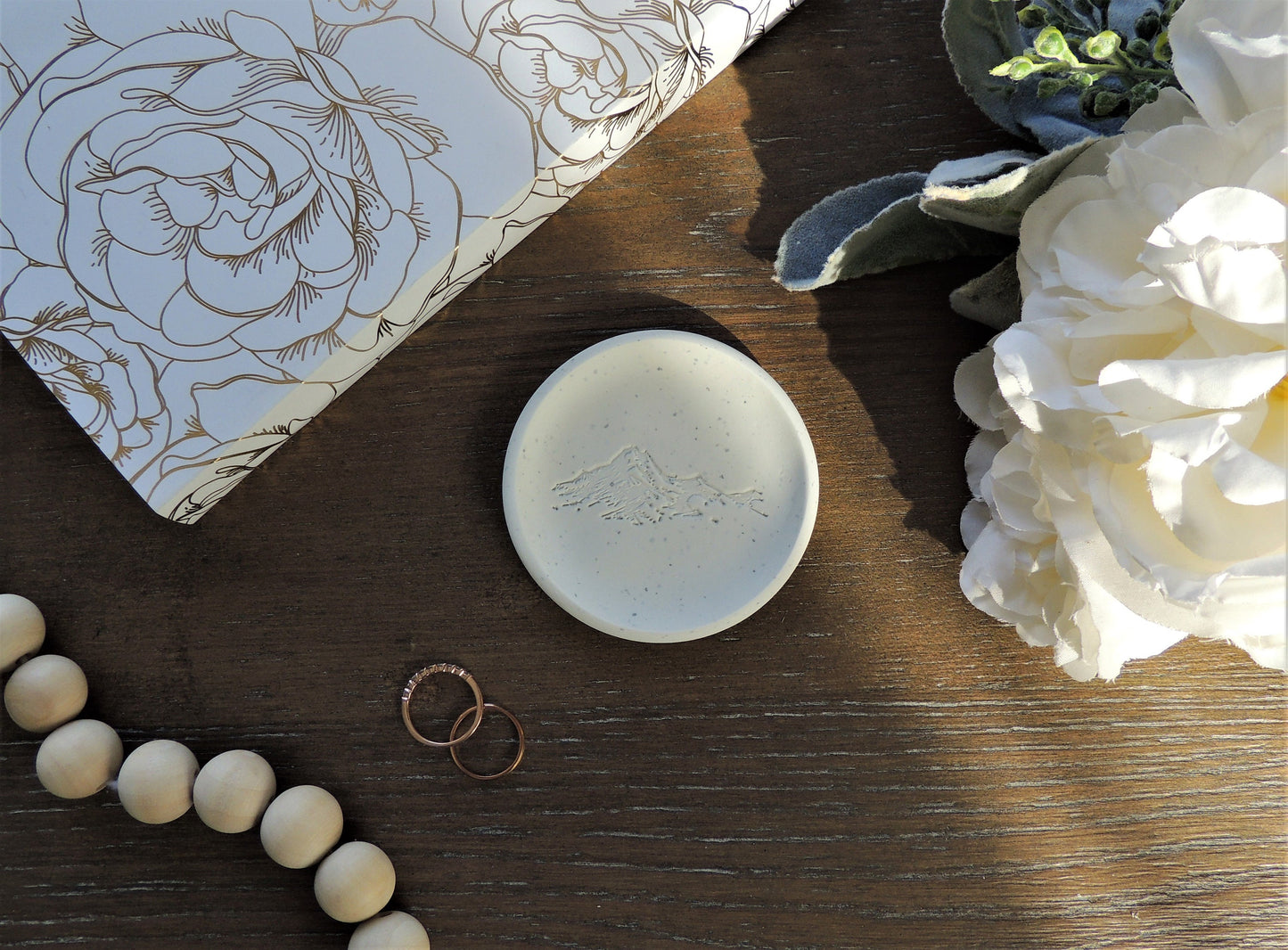 white speckled clay ring dish with mountain design