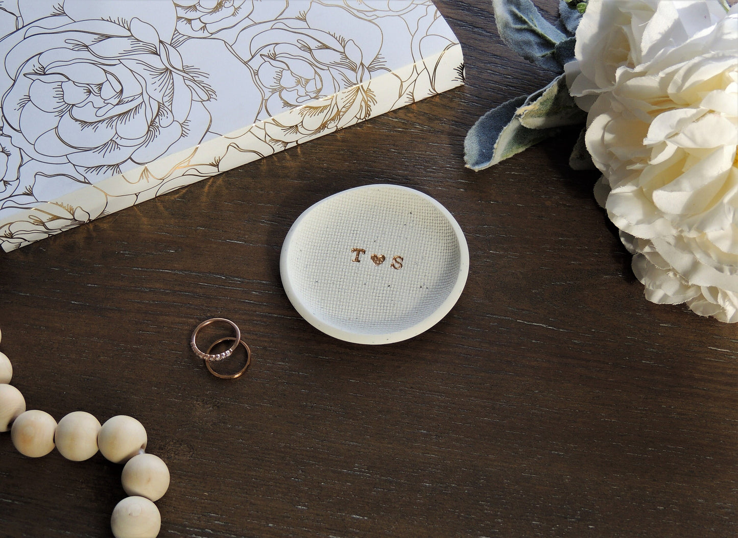 white speckle ring dish with letters in center in gold foil