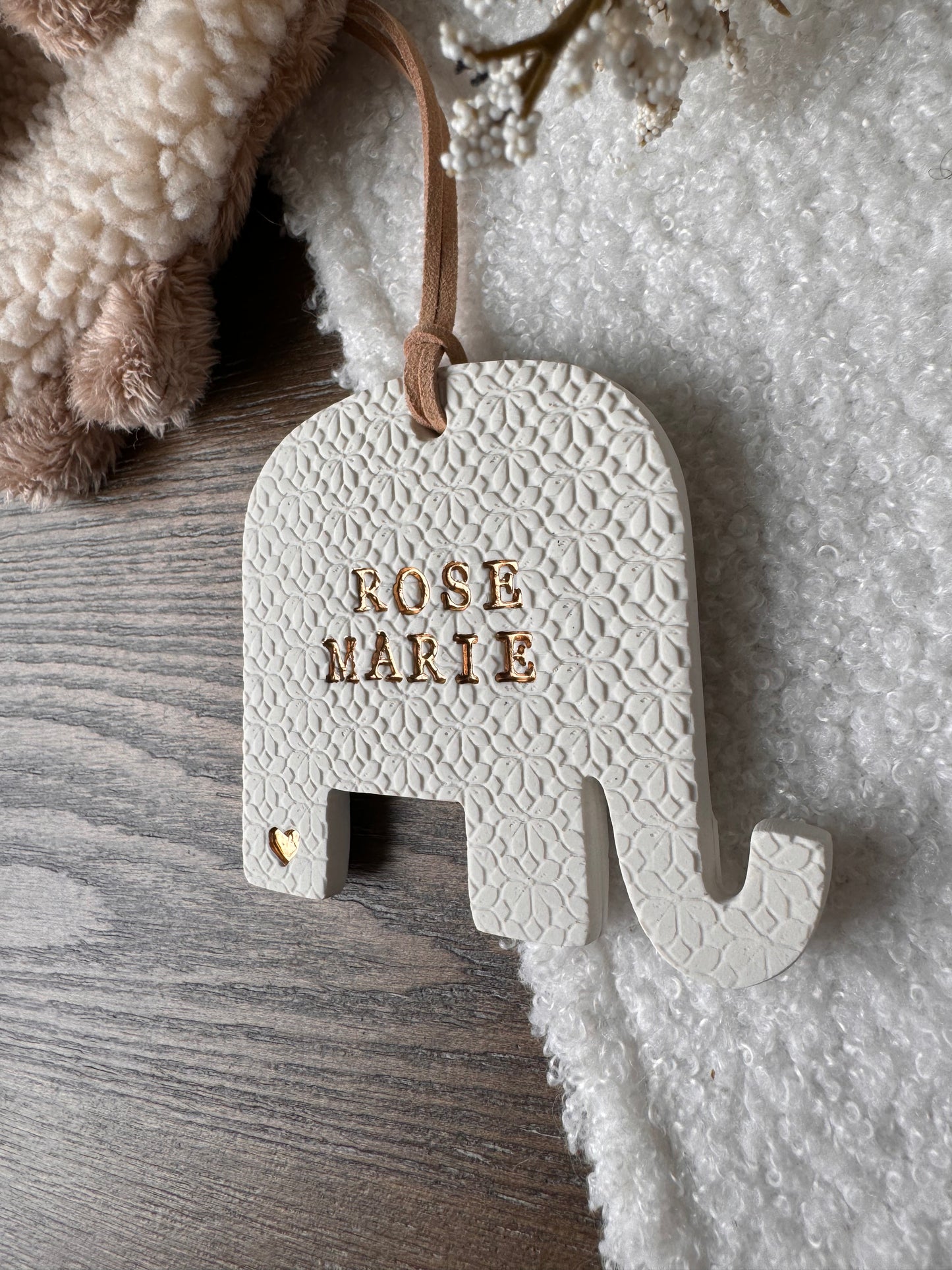 elephant shaped white clay ornament with personalized baby name with gold text
