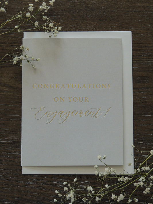 ivory card with gold foil lettering "congratulations on your engagement" simple