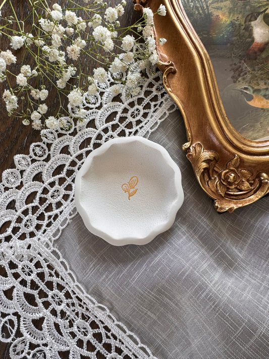 scalloped edge white clay ring dish with gold flower in center in flat lay photo, perfect for flat lay kit