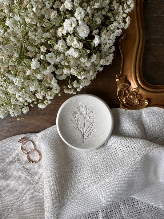 white ring dish with large flower design embossed and personalized name along flower design