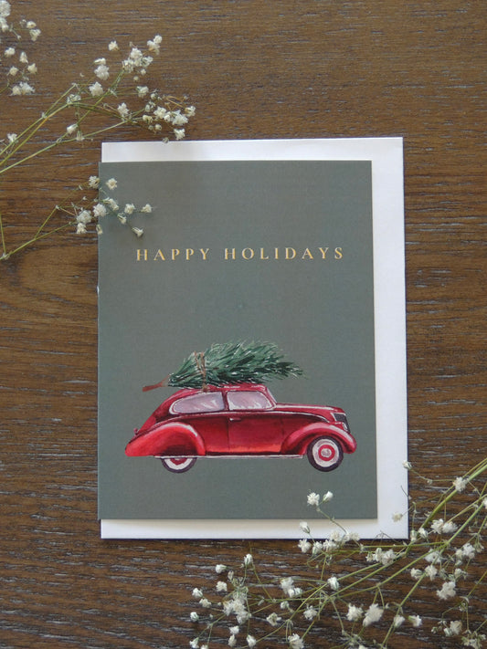 red car holiday card with Christmas tree on top of car