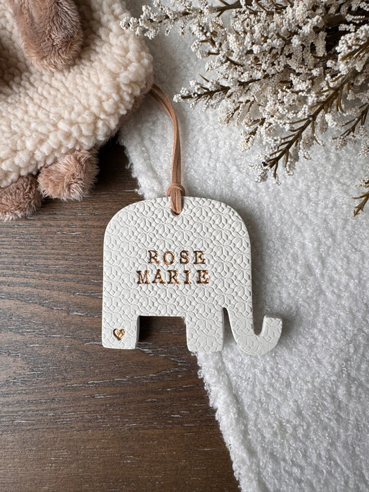 personalized elephant shaped ornament with custom name in gold text on white clay
