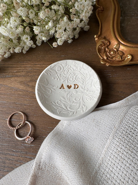textured ring dish with nature patter and gold initials in center of dish