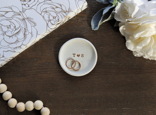 white speckle ring dish with letters in center in gold foil