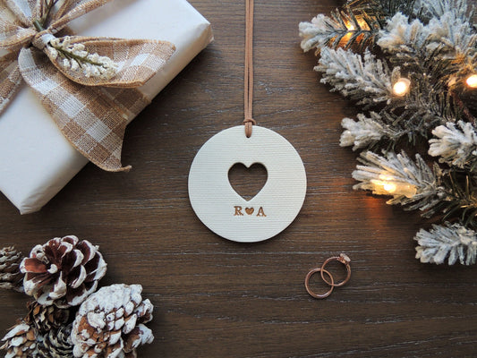 personalized white ornament with heart cut out and initials