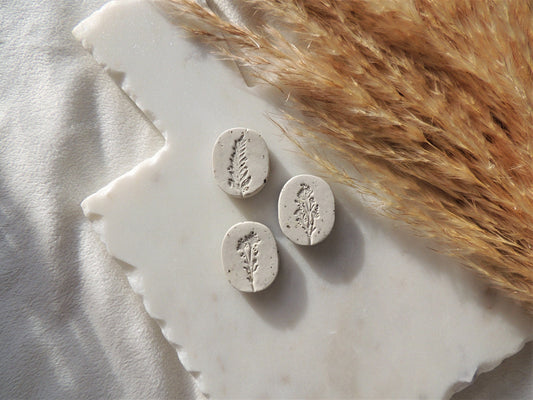 beige magnets with leafy floral design in center, oval shaped