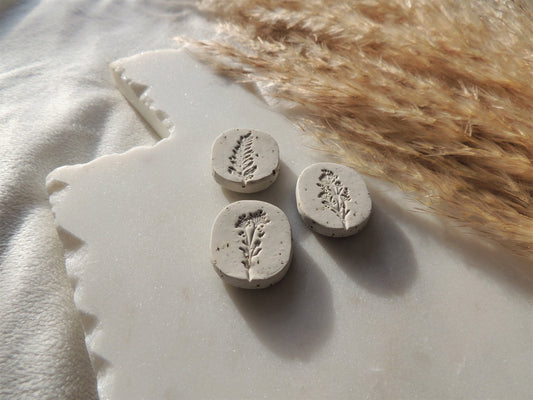 beige magnets with leafy floral design in center, oval shaped