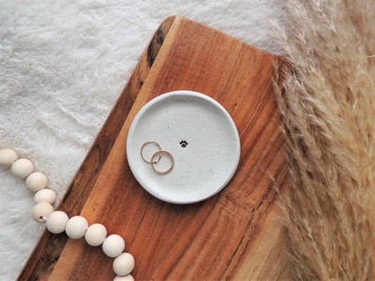 handmade ring dish with black paw print in center, made from white speckled clay