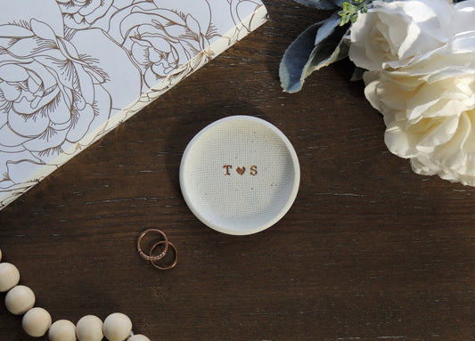 white speckle ring dish with letters in center in gold foil