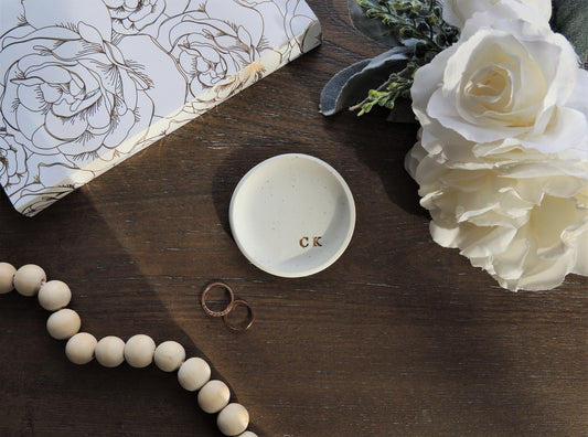 simple white clay ring dish with gold initials in bottom right