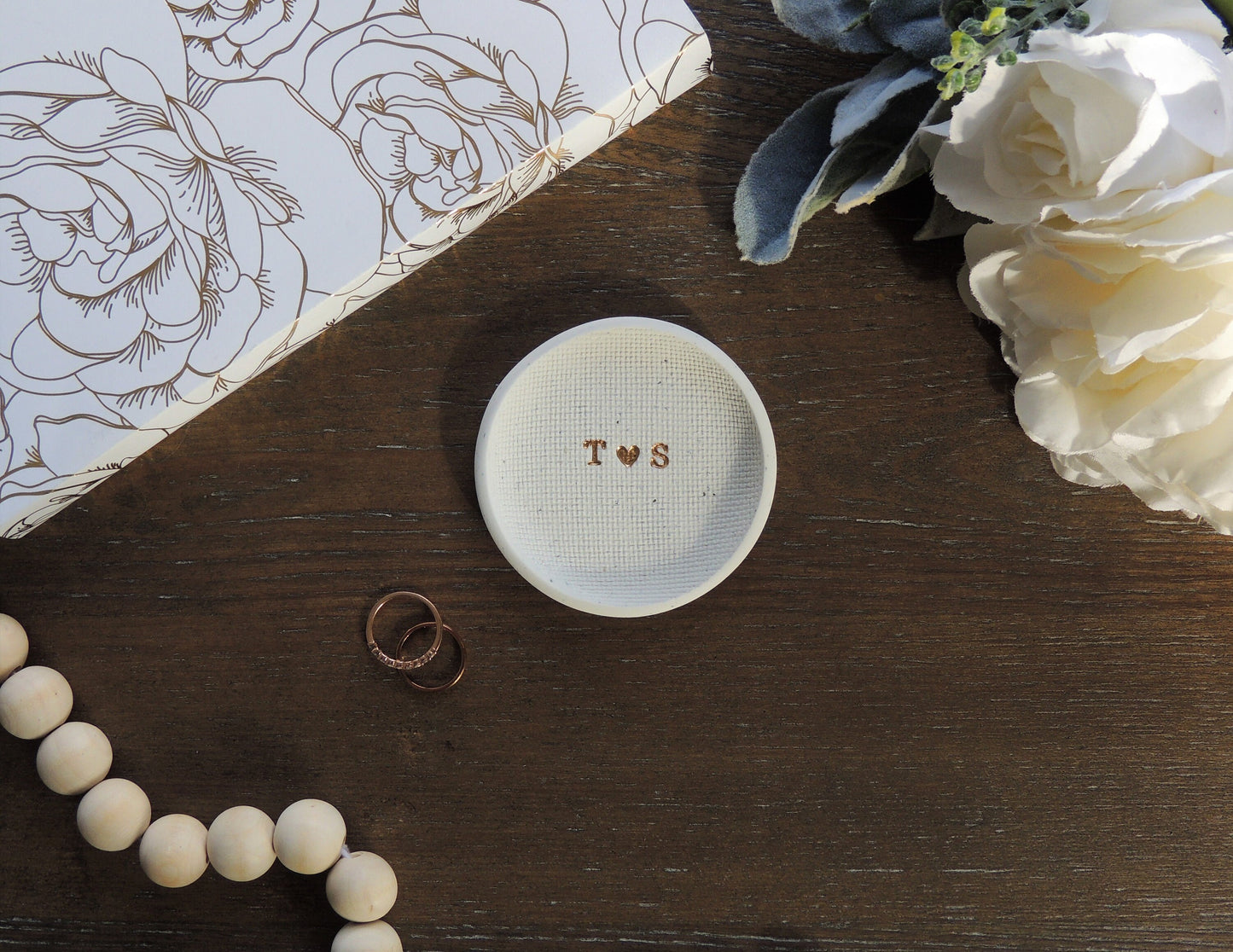 white speckle ring dish with letters in center in gold foil