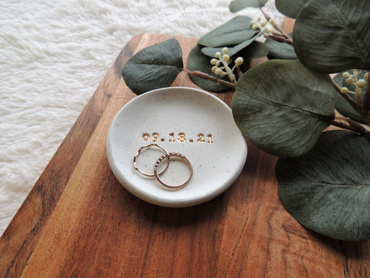 white speckled ring dish with gold date for wedding couples