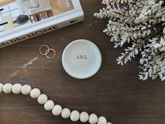 white jewelry dish with personalized gold foil initials in the center and floral lace pattern